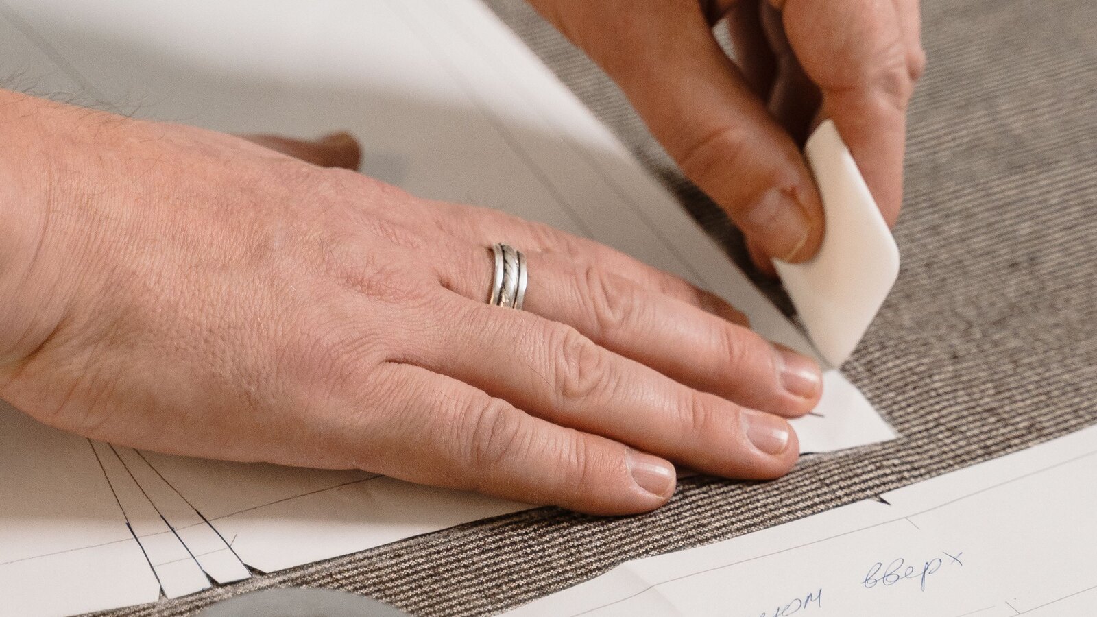 Tailor chalk marking measurements on grey wool cloth